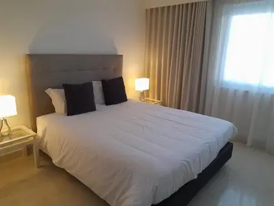 a bedroom with a large white bed with two lamps at Victory Village 2A in Quinta do Lago