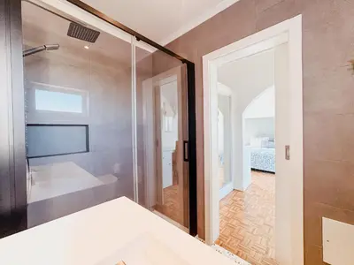 a bathroom with a shower and a glass door at Vila Channa - Adults Only in Albufeira