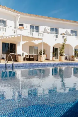 a swimming pool in front of a hotel at Vila Channa - Adults Only in Albufeira
