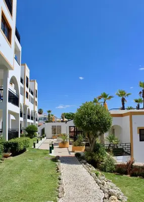 a row of white buildings with trees and grass at Alfagar Cerro Malpique in Albufeira
