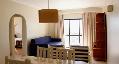 a living room with a blue couch and a table at Alfagar Cerro Malpique in Albufeira