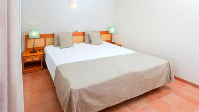a bedroom with a large white bed with two lamps at Alfagar Cerro Malpique in Albufeira