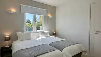 two beds in a small room with a window at Galo by Check-in Portugal in Albufeira
