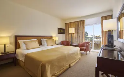 a hotel room with a bed and a balcony at PortoBay Falesia in Albufeira