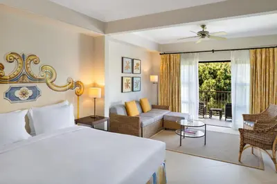 a bedroom with a bed and a living room at Pine Cliffs Residence, a Luxury Collection Resort, Algarve in Albufeira