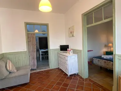 a living room with a couch and a bed and a television at Quinta das Amendoeiras in Albufeira