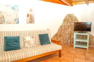 a living room with a couch and a flat screen tv at Quinta das Amendoeiras in Albufeira