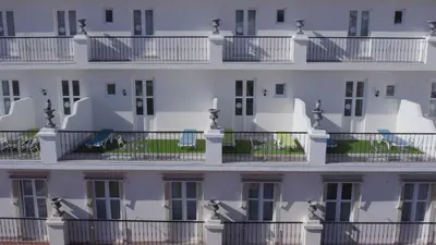 a white building with balconies on it at Albufeira Beach Hotel by Kavia in Albufeira