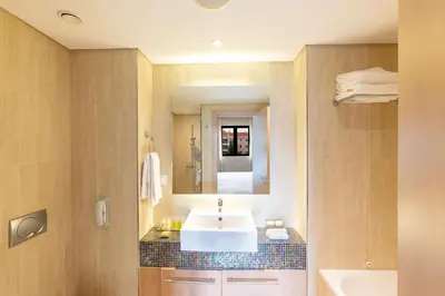 a bedroom with a large bed and two chairs at Hilton Vilamoura in Vilamoura