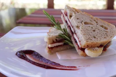 a sandwich is cut in half on a white plate at Quinta Do Mel in Albufeira