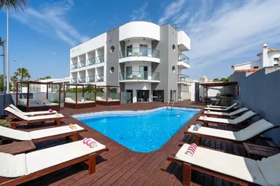 a hotel with a swimming pool and lounge chairs at KR Hotels - Albufeira Lounge in Albufeira