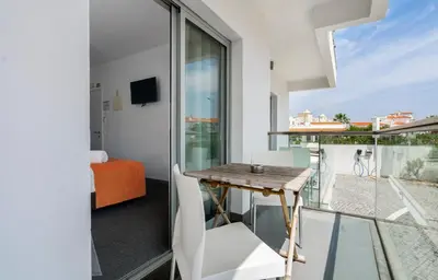 a room with a table and a balcony with a view at KR Hotels - Albufeira Lounge in Albufeira