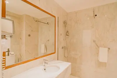 a bathroom with a sink and a shower with a mirror at Velamar Boutique Hotel - Adults Friendly in Albufeira