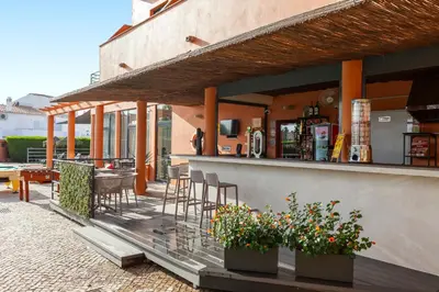 a bar on a patio with chairs and flowers at Hotel Praia Sol in Quarteira