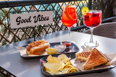 a table with two plates of food and two drinks at Hotel Praia Sol in Quarteira
