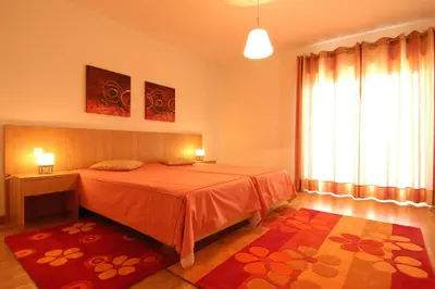 a bedroom with a bed and a large window at Orada Apartamentos Turísticos - Marina de Albufeira in Albufeira