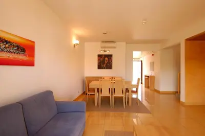 a living room with a table and a blue couch at Orada Apartamentos Turísticos - Marina de Albufeira in Albufeira