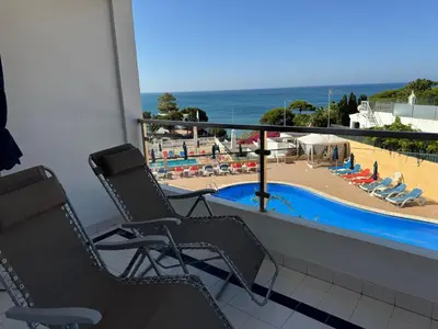 a balcony with two chairs and a view of the beach at Apartamentos Do Parque in Albufeira