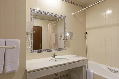 a bathroom with a sink and a mirror and a tub at Apartamentos Do Parque in Albufeira
