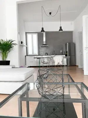 a living room with a glass table and a kitchen at Atelier 3 - Boutique Rooms in Loulé