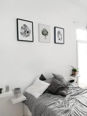 a bedroom with a bed and four pictures on the wall at Atelier 3 - Boutique Rooms in Loulé