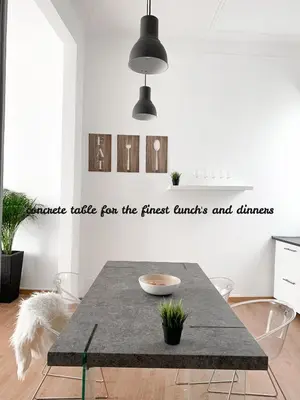 a dining room with a concrete table for the finest amusements and dinners at Atelier 3 - Boutique Rooms in Loulé