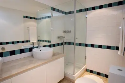 a bathroom with a sink and a glass shower at Varandas de Carteia G/F in Quarteira