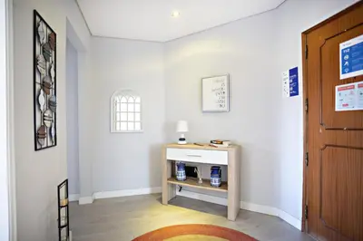 a hallway with a small table and a door at Apartamento Gulbenkian in Faro