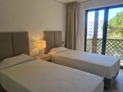 two beds in a hotel room with a balcony at Apartamento Falésia by Garvetur in Albufeira