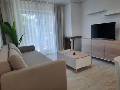 a living room with a couch and a flat screen tv at Apartamento Falésia by Garvetur in Albufeira