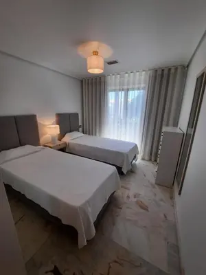 a hotel room with two beds and a window at Apartamento Falésia by Garvetur in Albufeira