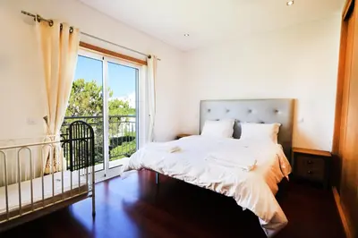 a bedroom with a bed and a large window at Balaia Harmonia in Albufeira