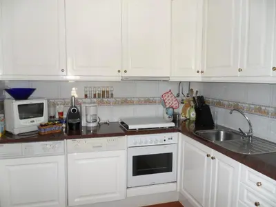 a white kitchen with white cabinets and a sink at Casa na praia e golfe in Vale do Lobo
