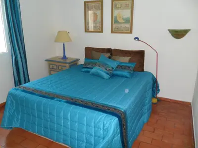a bedroom with a blue bed with blue pillows at Casa na praia e golfe in Vale do Lobo