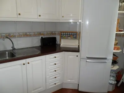 a kitchen with white cabinets and a white refrigerator at Casa na praia e golfe in Vale do Lobo
