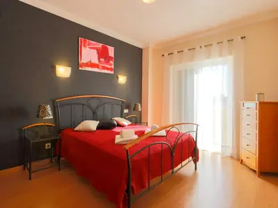 a bedroom with a red bed with a red blanket at Luxury Holiday Villa Alegria Galé Beach, Albufeira in Albufeira
