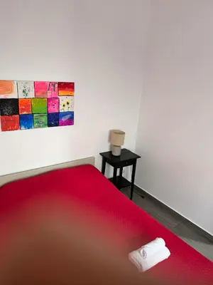 a bedroom with a red bed and a painting at Casinha in Faro