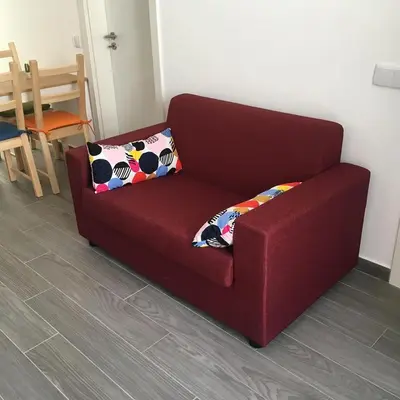 a red couch with two pillows in a living room at Casinha in Faro