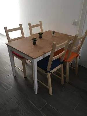 a wooden table with four chairs and a table with plants on it at Casinha in Faro