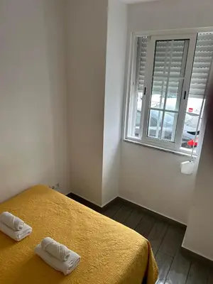 a bedroom with a bed and a window at Casinha in Faro