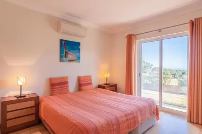 a bedroom with a bed and a large window at Villa Costa by Gabi Miguel in Albufeira