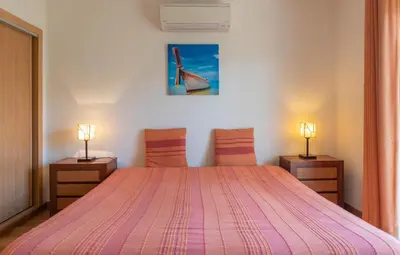 a bedroom with a large bed with a pink blanket at Villa Costa by Gabi Miguel in Albufeira