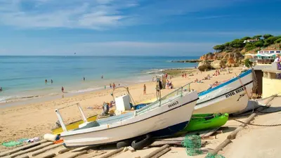 a group of people on a beach in front of cliffs at Apartament Olhos do Mar T1 beach Olhos de Água in Albufeira