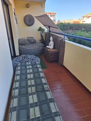 a meditating statue sitting on a table with an umbrella at Apartament Olhos do Mar T1 beach Olhos de Água in Albufeira