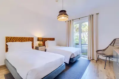 a hotel room with two beds and a window at Pine Cliffs Village in Albufeira