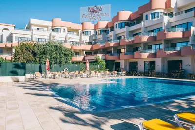 a hotel with a swimming pool in front of a building at Grand Muthu Forte Da Oura in Albufeira