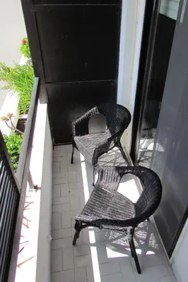 two wicker chairs sitting on a balcony at In Faro with Sea View in Faro