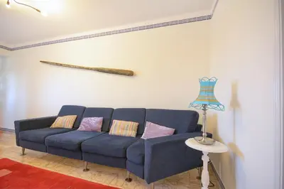 a blue couch in a living room with a lamp at In Faro with Sea View in Faro