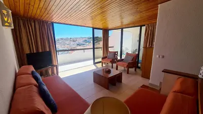 a living room with a red couch and a large window at Albufeira Ocean Terrace (31) in Albufeira