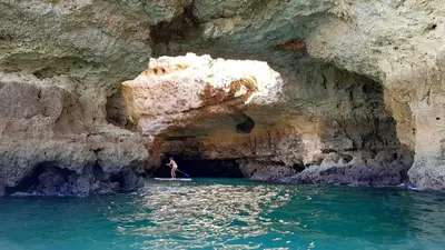 a person standing in a cave in the water at Albufeira Ocean Terrace (31) in Albufeira